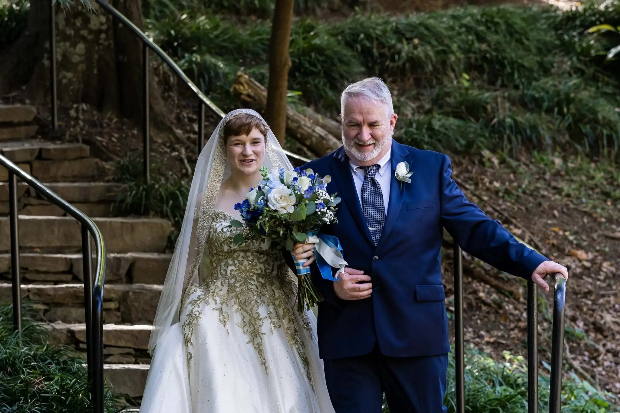 Jessica and Hayden wedding at Grand Bohemian Lodge Greenville, SC — the bride on her father’s arm walking down garden steps