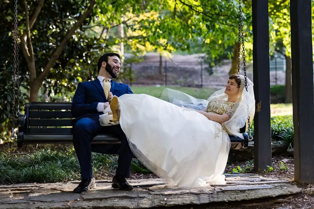 Jessica reclining in a garden swing while Hayden sits on the bench beside her