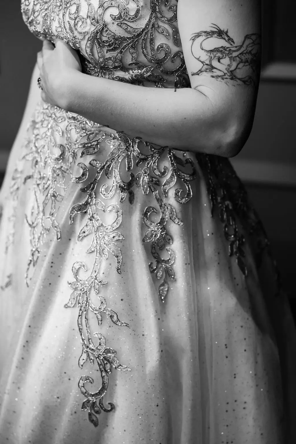 Black and white detail of the beaded gold scrollwork on the wedding gown's skirt