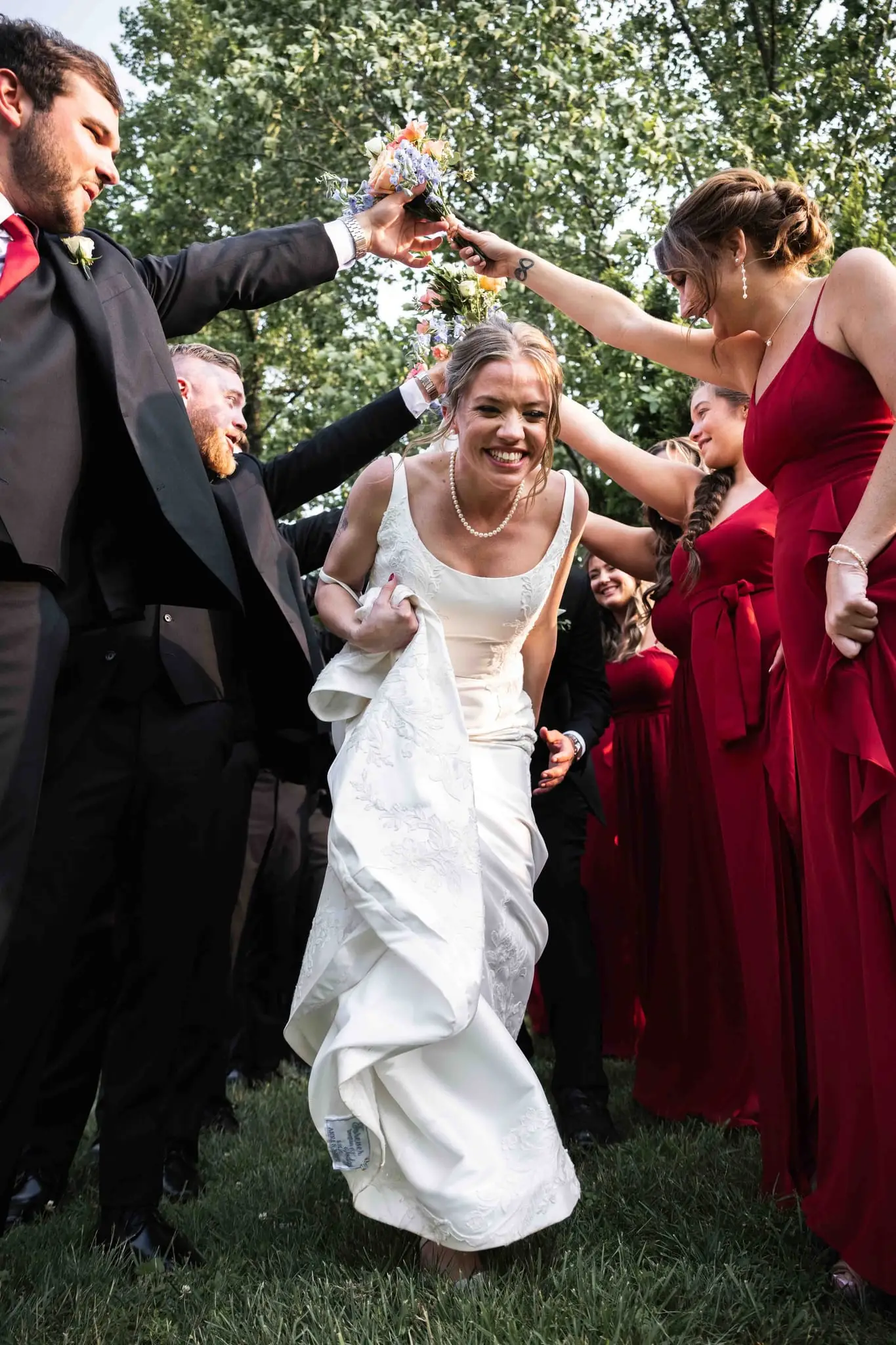 Anna and Joseph wedding at The Crest Center & Pavilion, Asheville NC — the bride running through a tunnel of guests' raised arms and bouquets