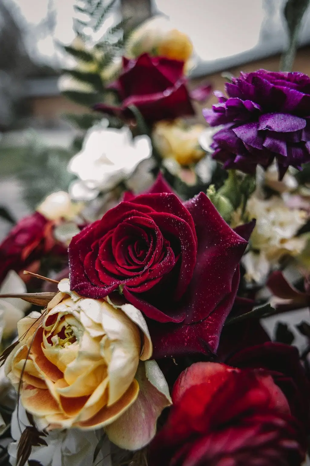 Close-up of a bridal bouquet of deep red and golden roses