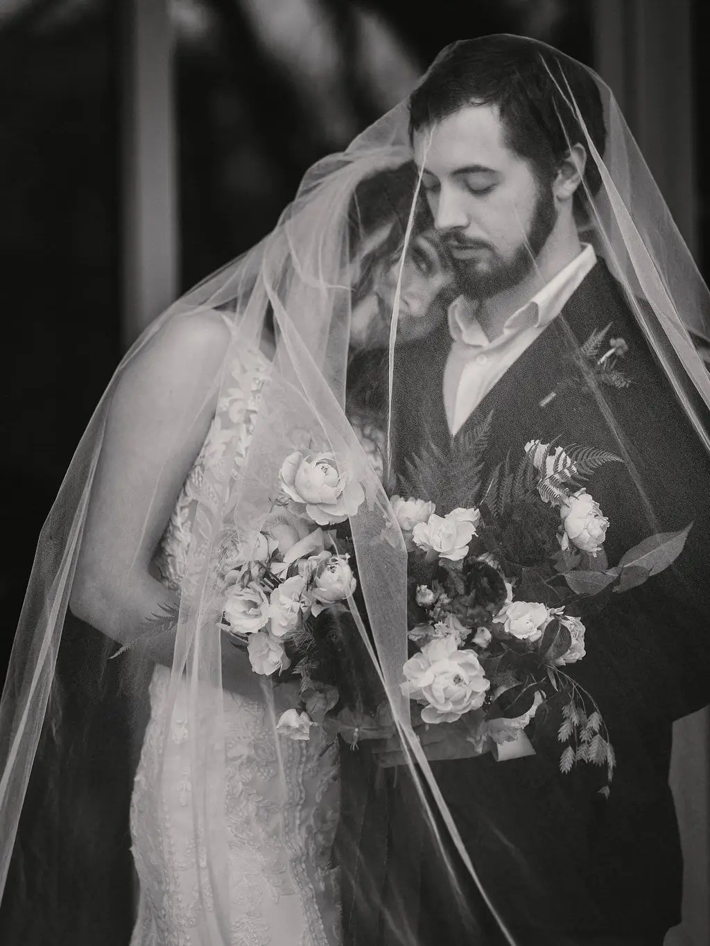 Moody portrait of a couple under a sheer veil at Haiku I Do in Asheville