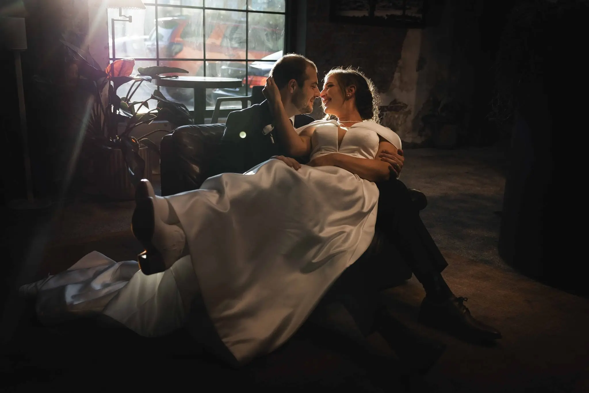 Couple on the sofa with a soft sun flare streaking in from the window