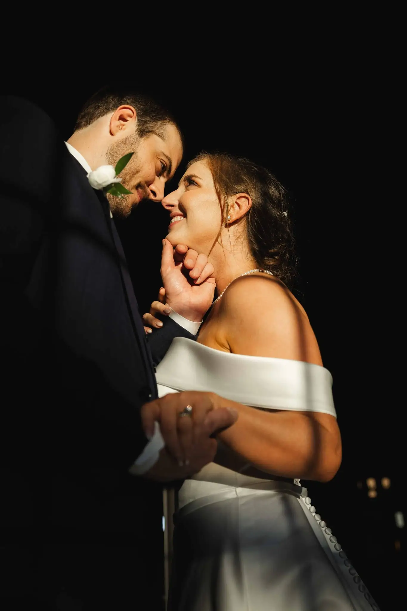 Groom and bride in dramatic hard light and shadow inside the Conrad Nashville