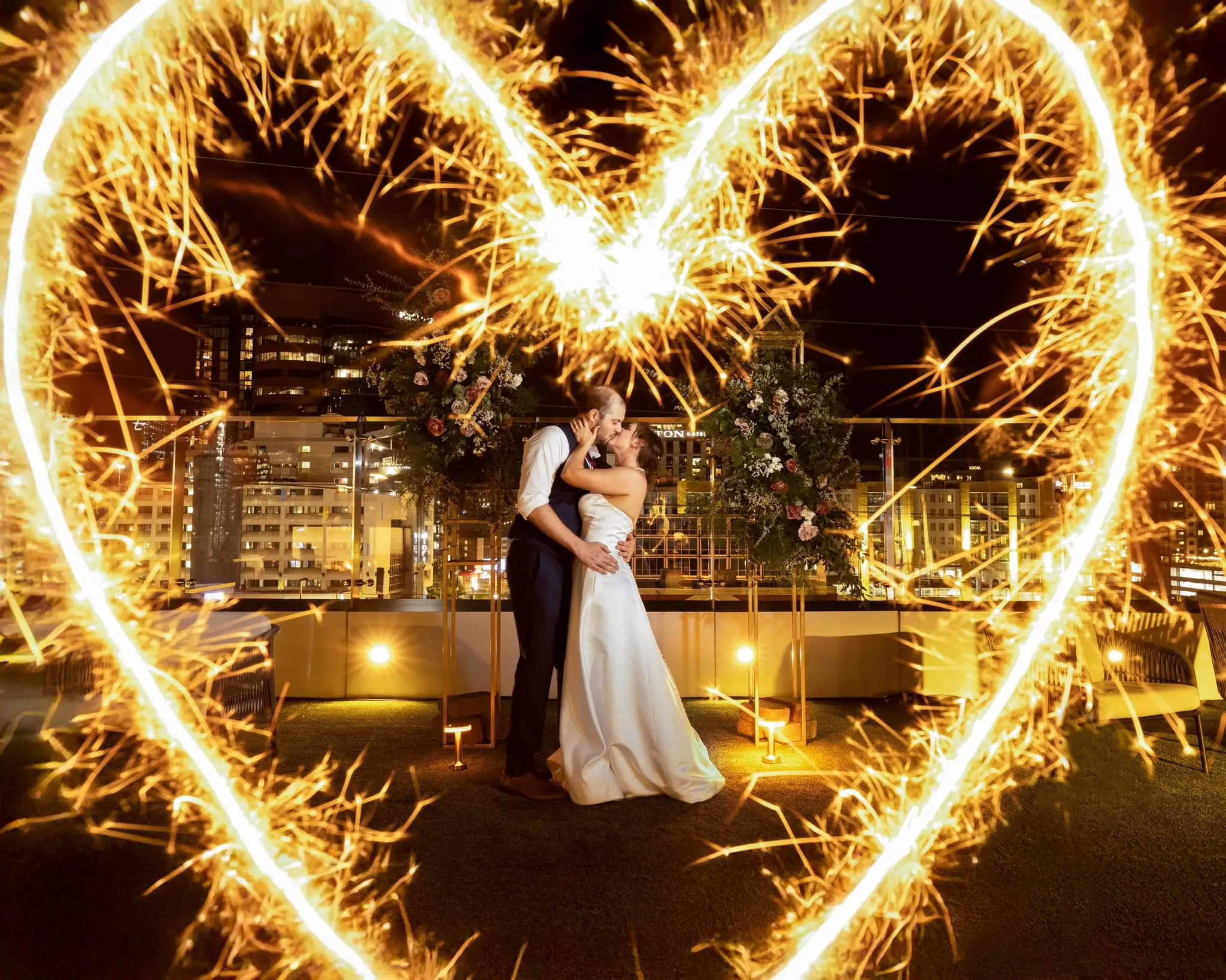 A couple framed by a sparkler heart at night at the Conrad Nashville