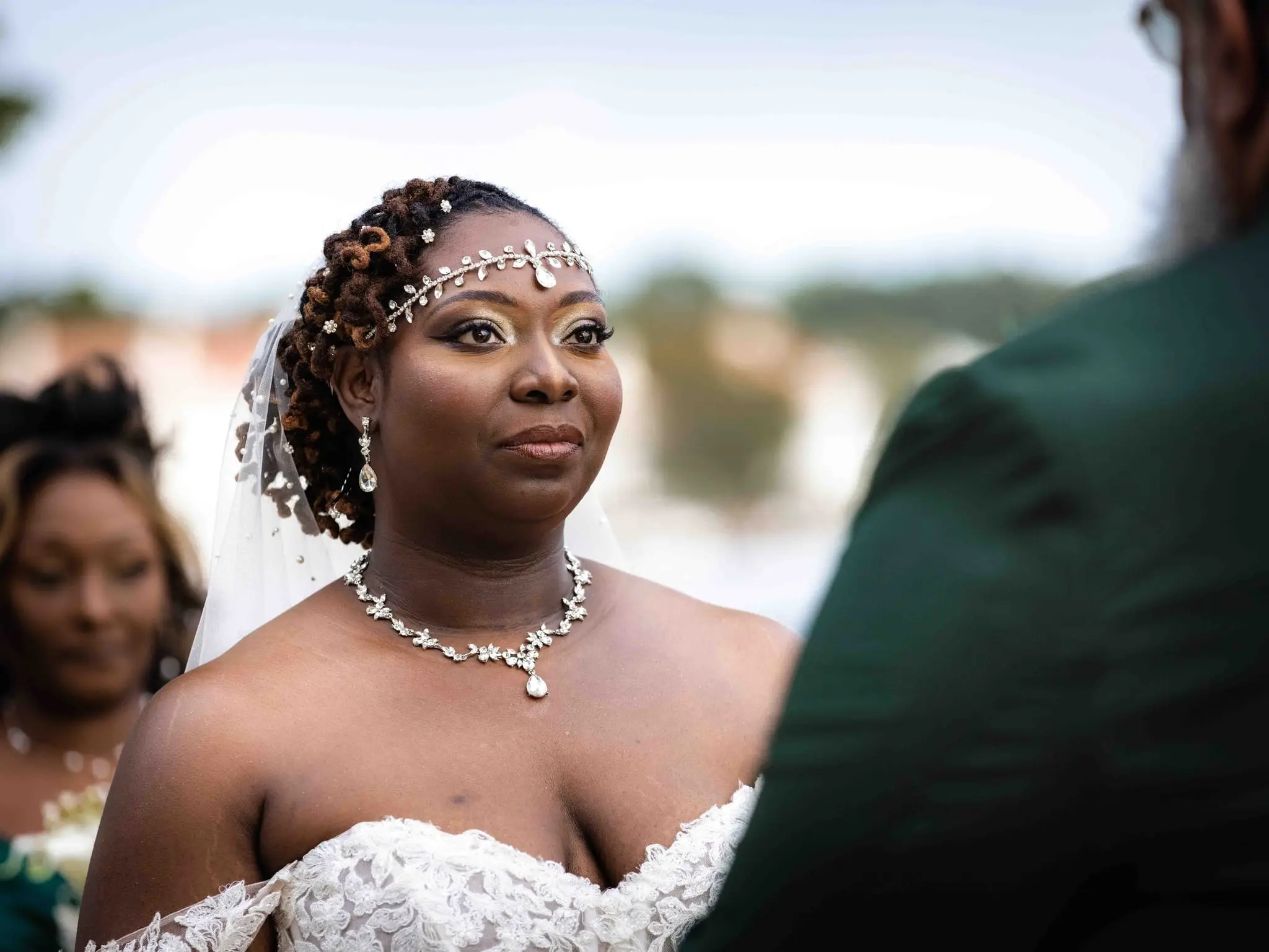 Close portrait of the bride in a beaded headpiece and crystal necklace during the ceremony