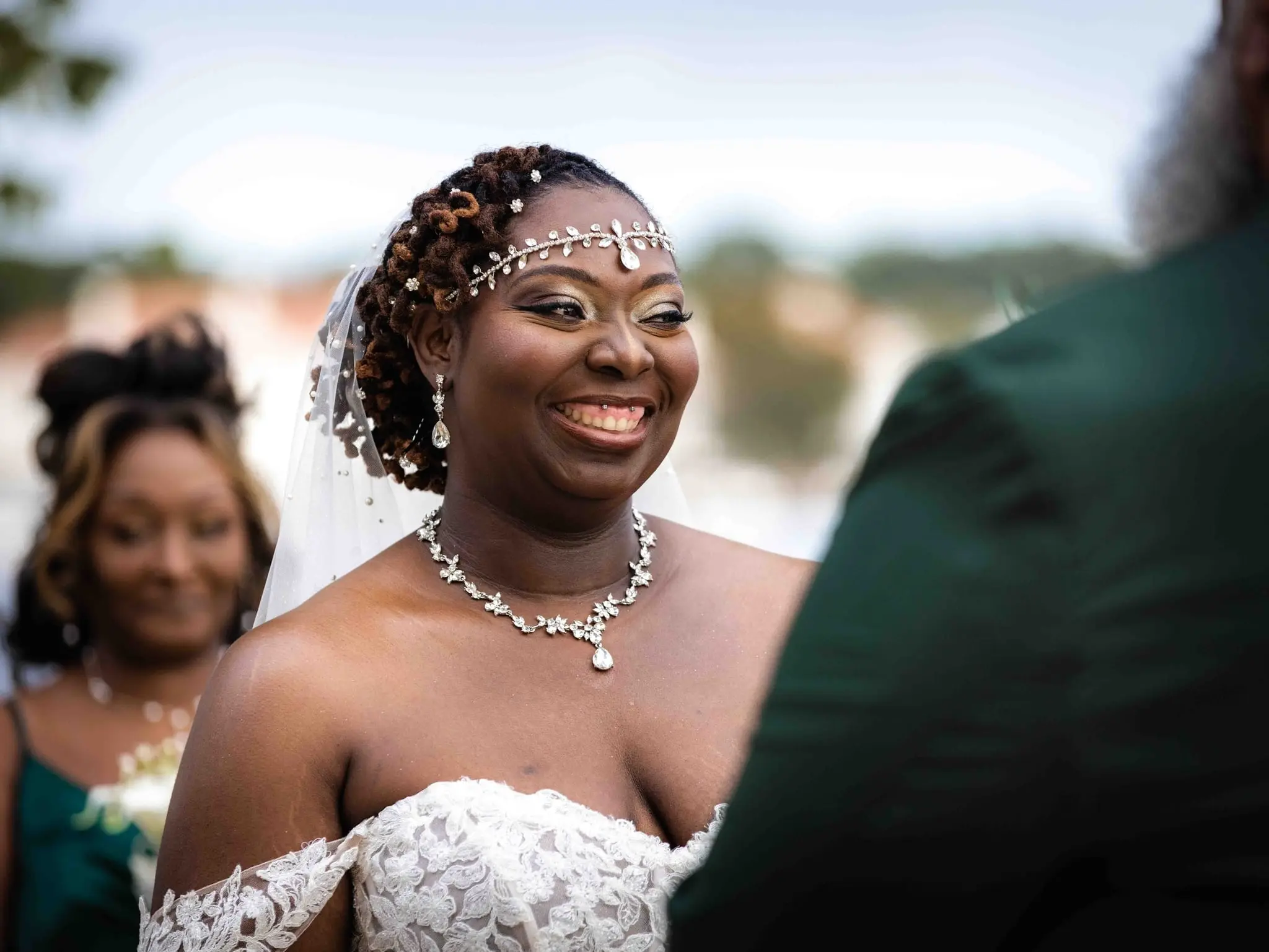 Bride beaming at the ceremony, wearing a beaded headpiece and crystal necklace