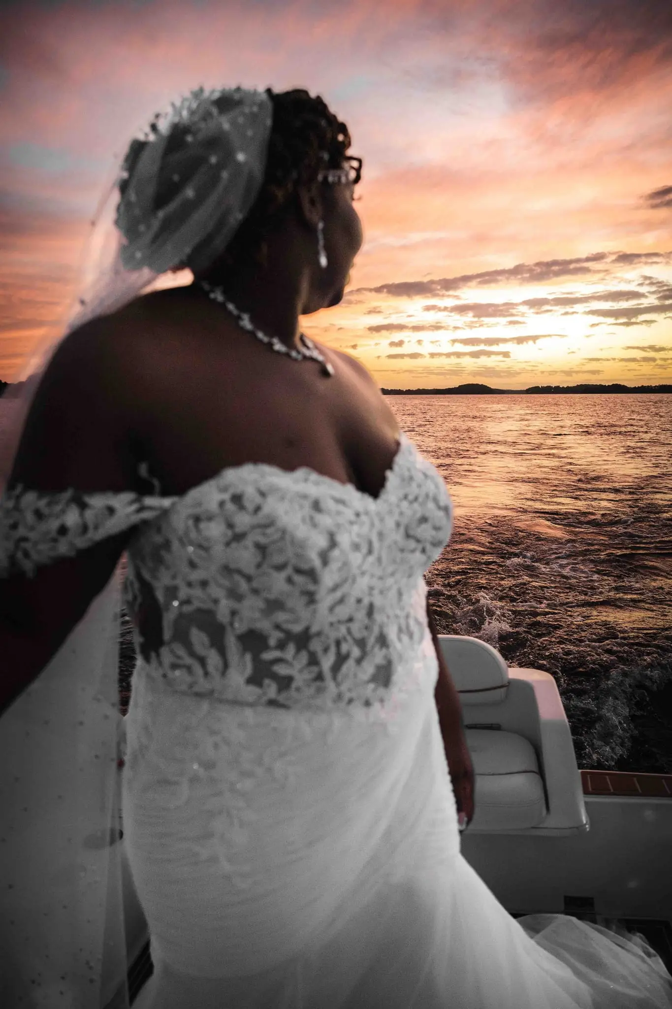Close portrait of the bride in profile, looking out over the lake at sunset
