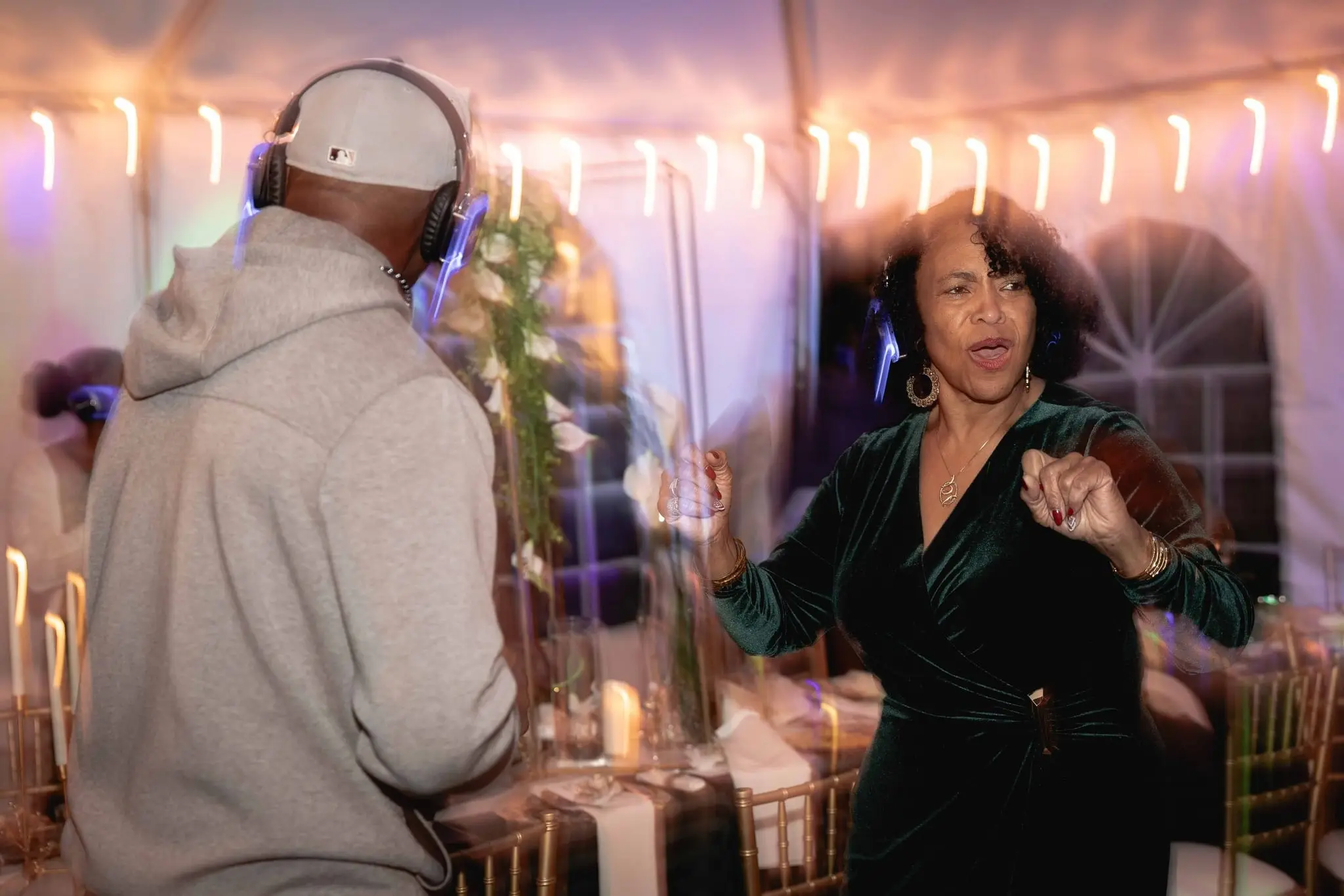 Motion-blurred dancing at the reception with guests in light-up headphones
