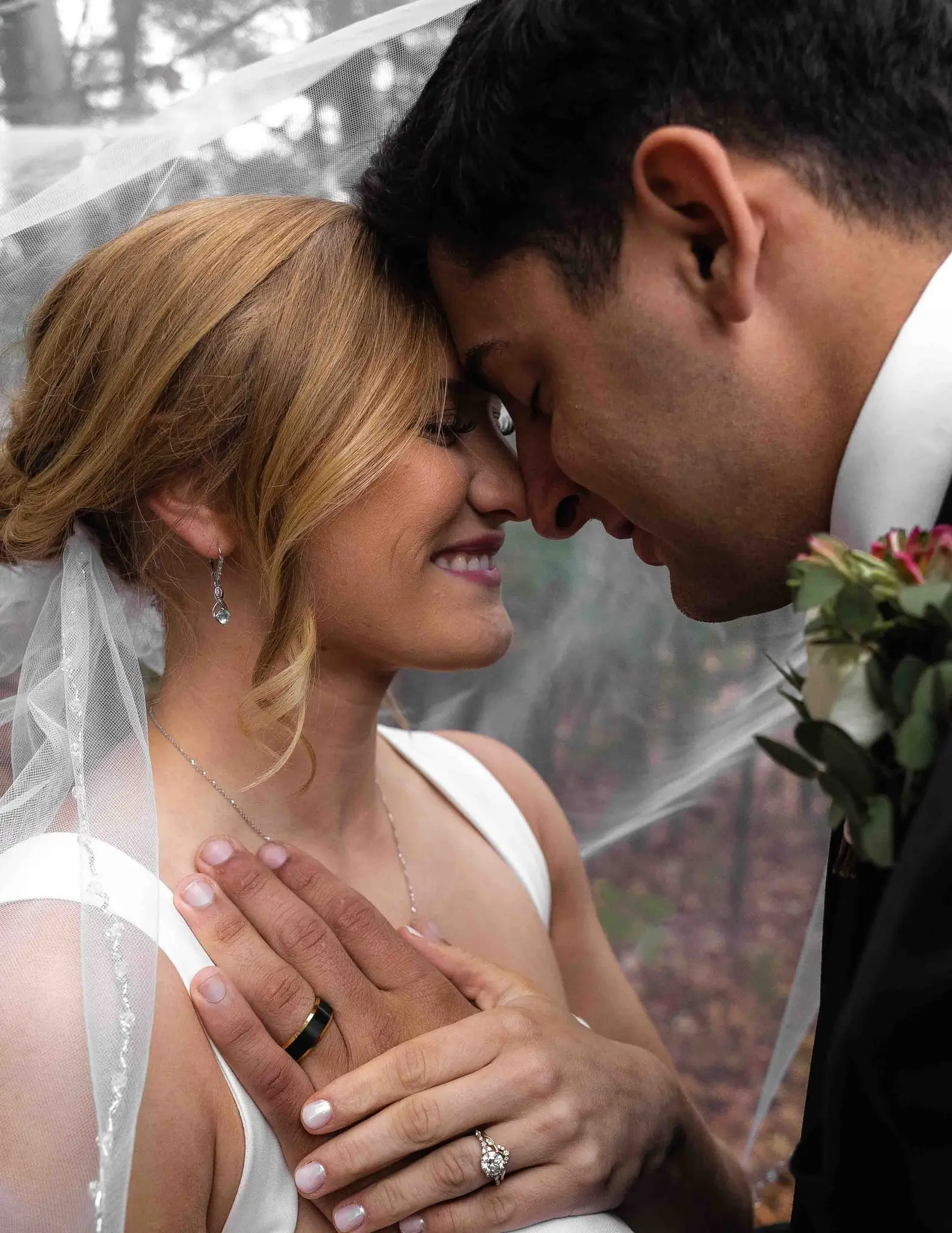 Lauren and Damian wedding at The Lodge at Flat Rock, Flat Rock NC — a close portrait of the couple foreheads together under the veil, the bride's ringed hand in front