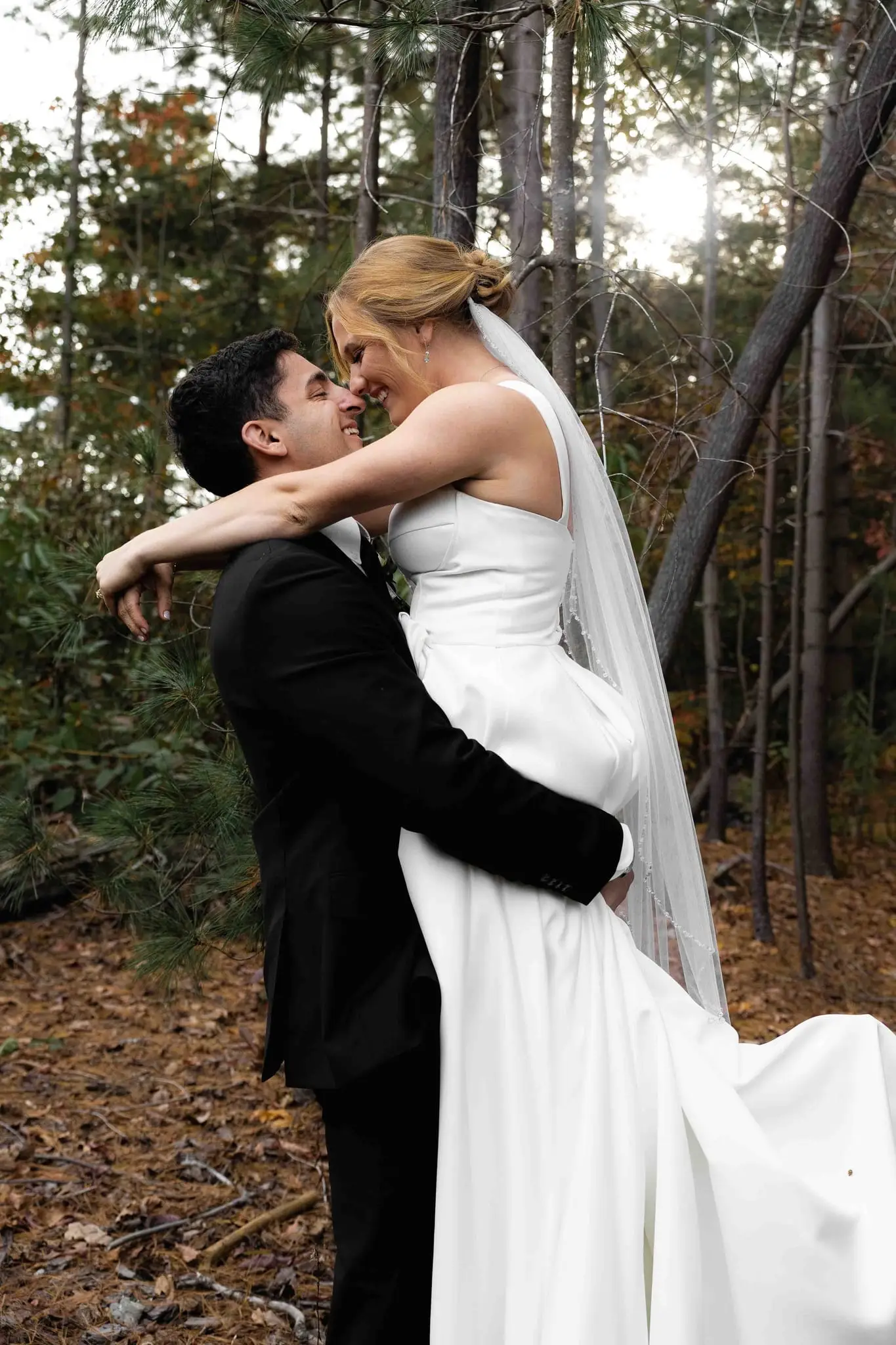 Lauren and Damian wedding at The Lodge at Flat Rock, Flat Rock NC — the groom lifting the bride in the autumn woods