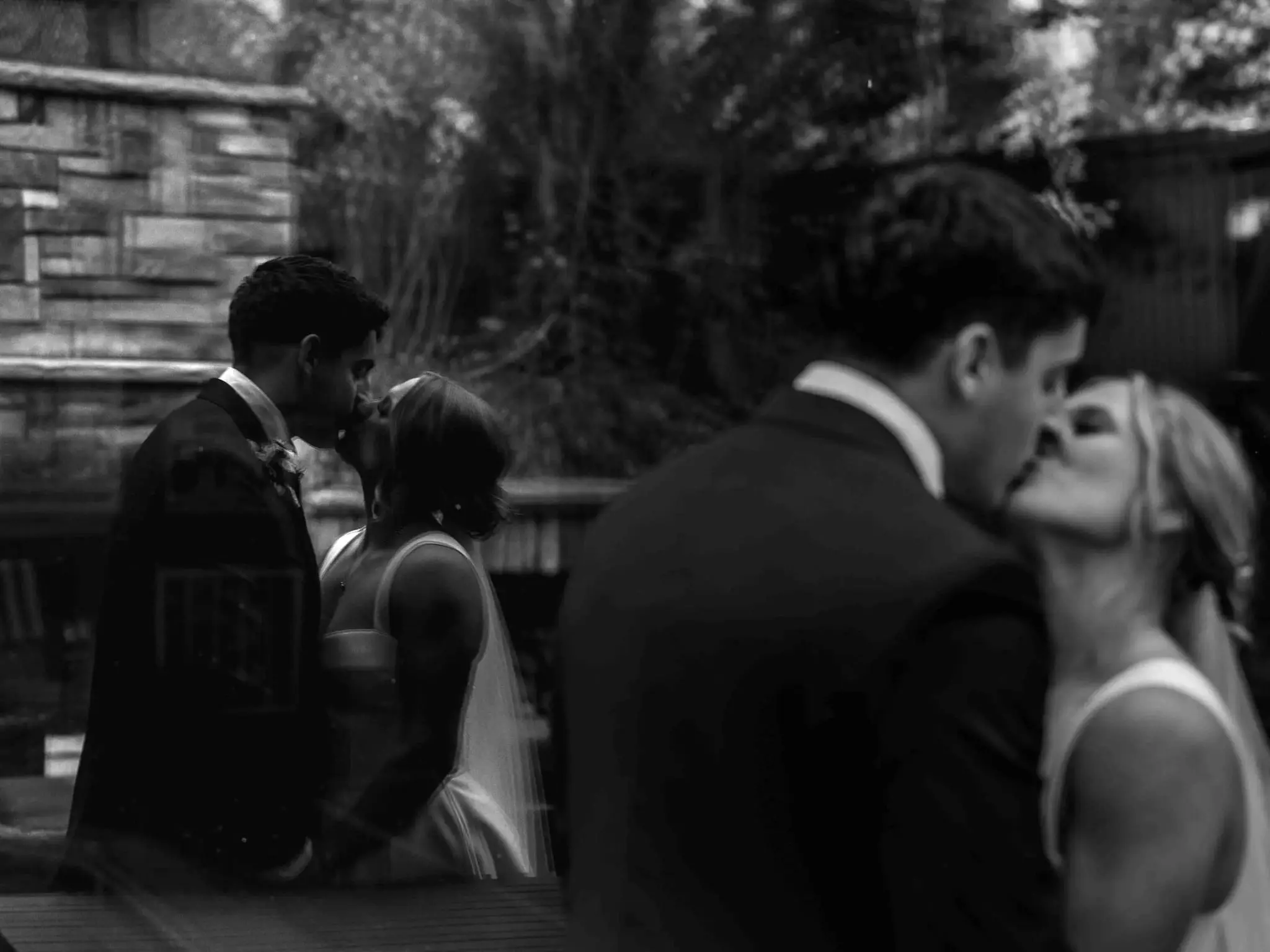 Black and white layered image of a bride and groom kissing, repeated in two overlapping frames