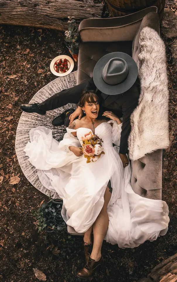 Overhead view of Juan and Jessica on a mauve velvet sofa at an editorial styled shoot in Asheville