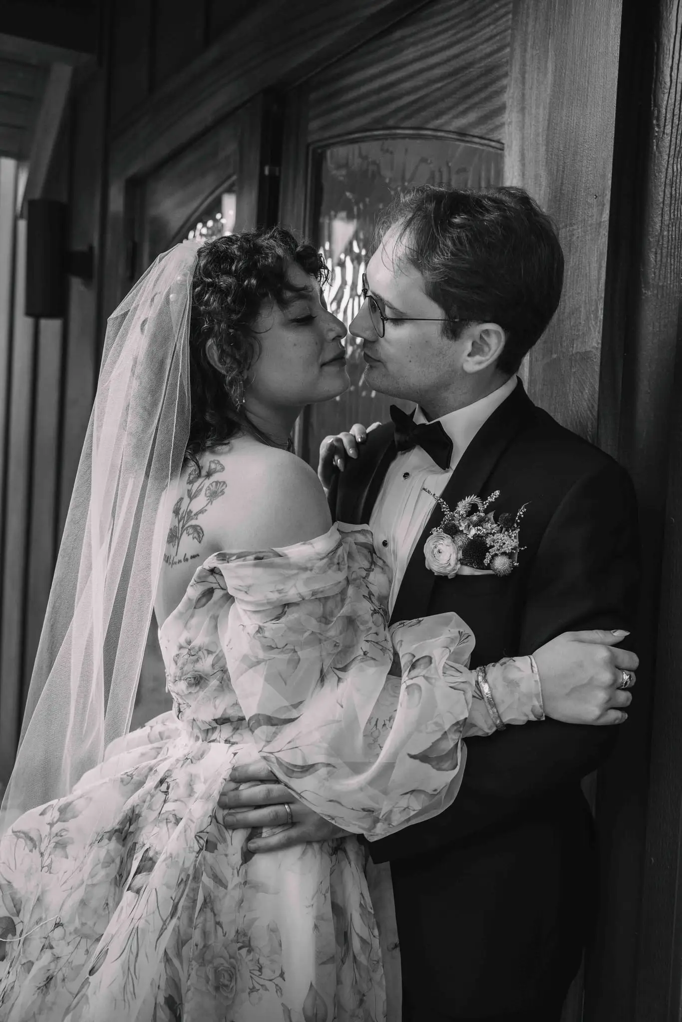 Maya and Jeff wedding at Weaver House, Weaverville NC — the couple kissing as the bride’s veil lifts, black and white