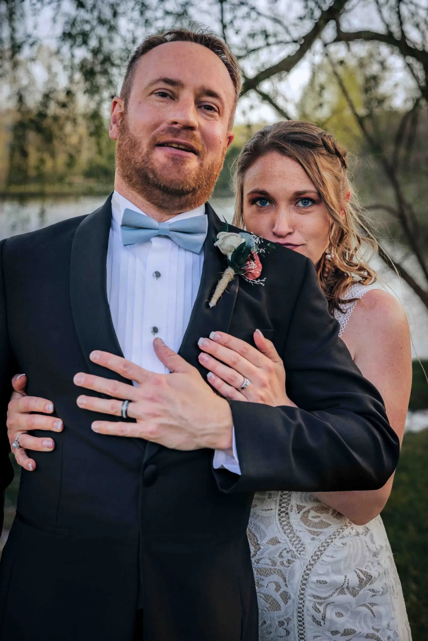 Groom in a powder-blue bow tie with Jessie's arms around him at Claxton Farm, Asheville